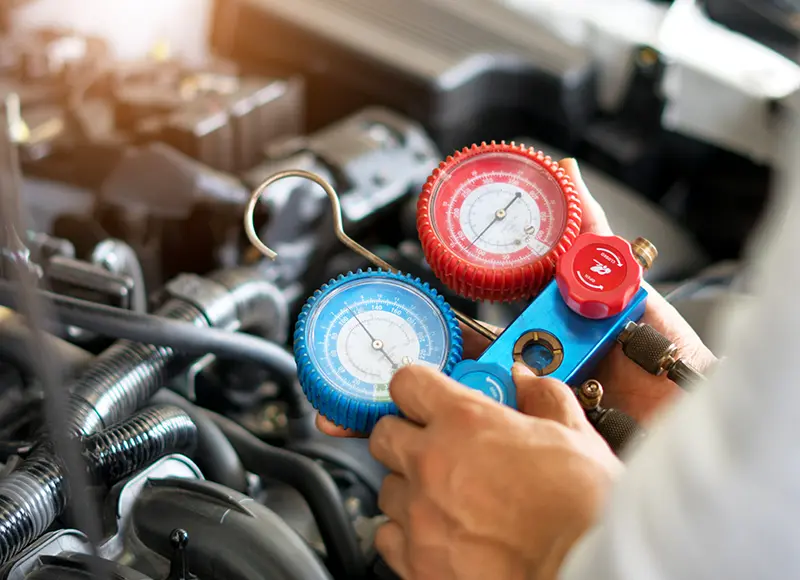 Technician using a meter tool in a service center.
