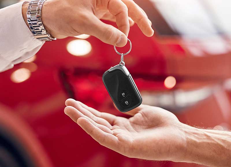 A customer giving their car keys to a car dealer after a trade-in